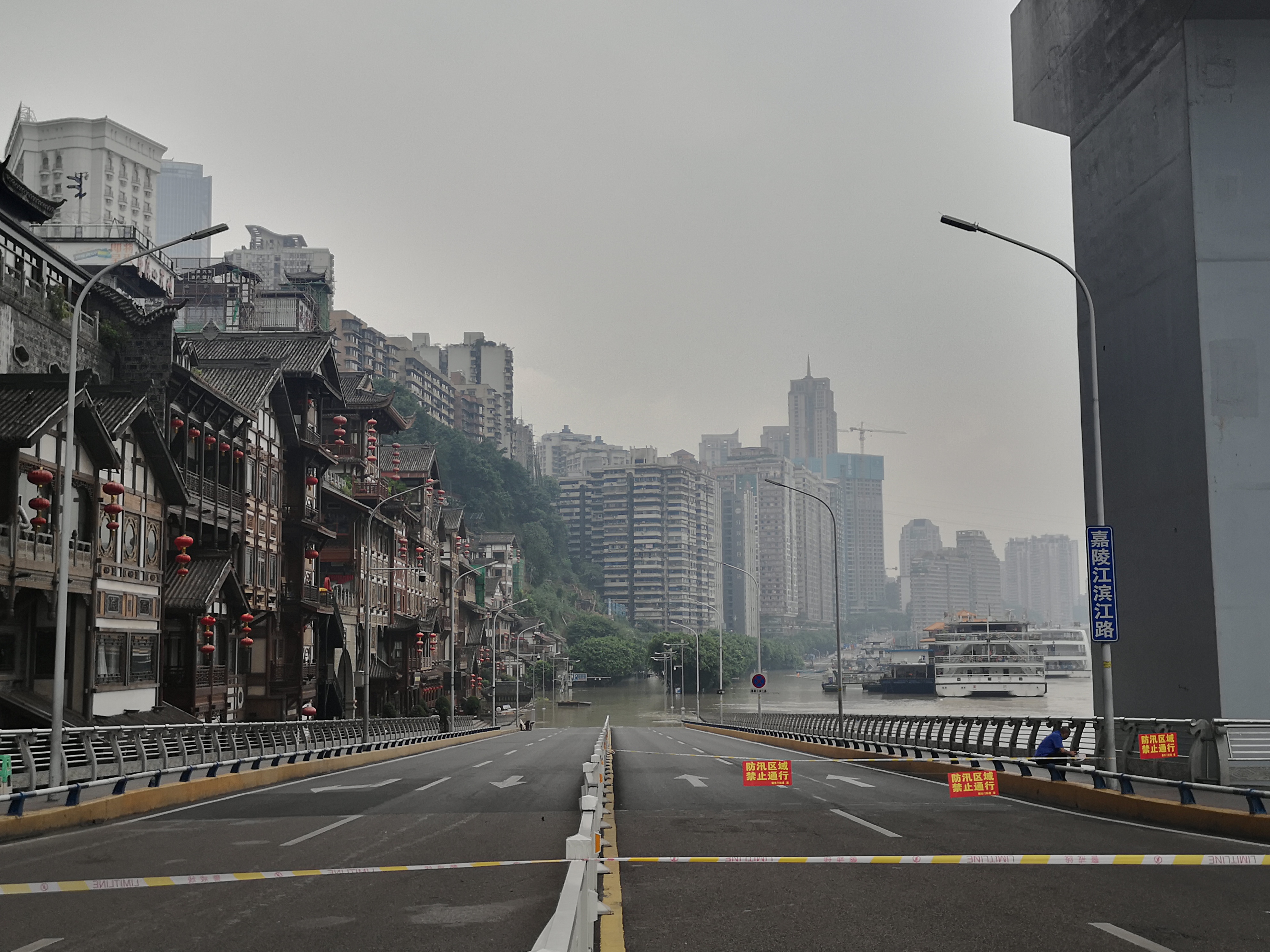 嘉陵江滨江路被淹没，画面左侧为洪崖洞景区。